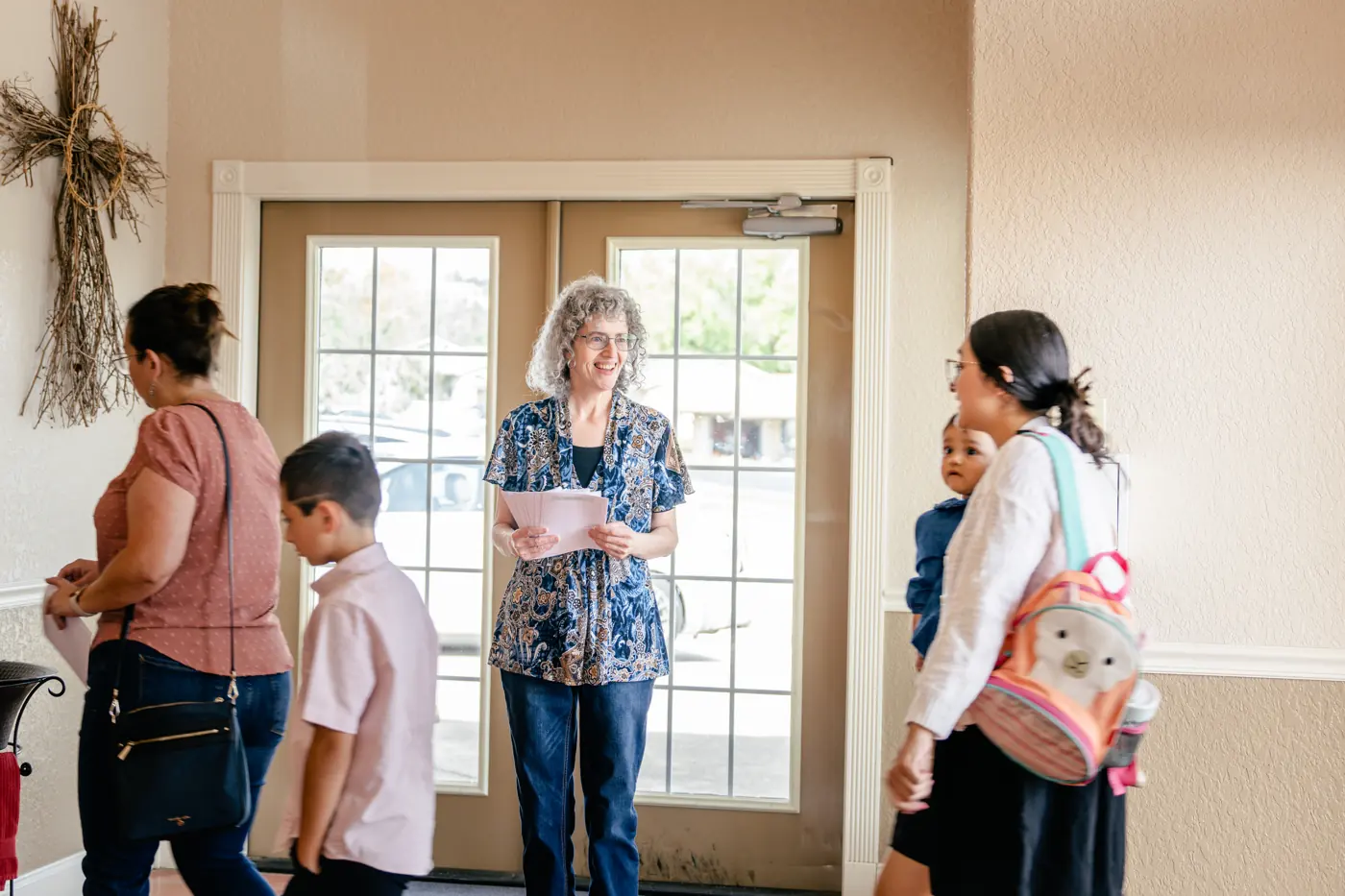 A greeter welcoming a family as they arrive at church